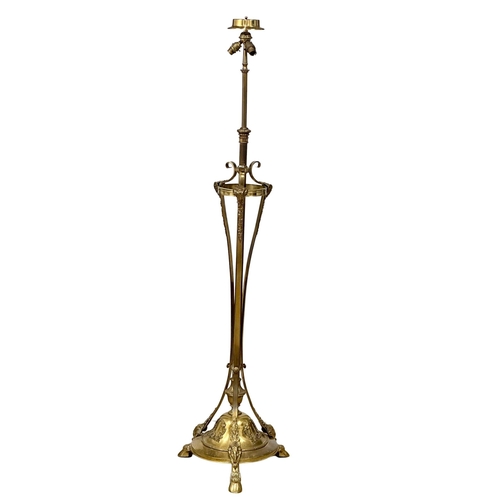 70 - A large good quality Early 20th Century brass standard lamp., with rams head decoration on hairy hoo... 