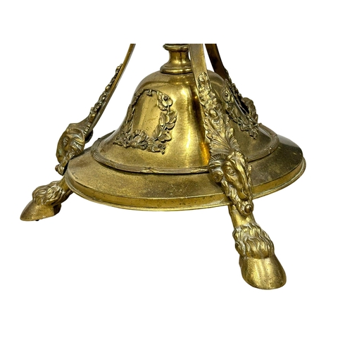 70 - A large good quality Early 20th Century brass standard lamp., with rams head decoration on hairy hoo... 