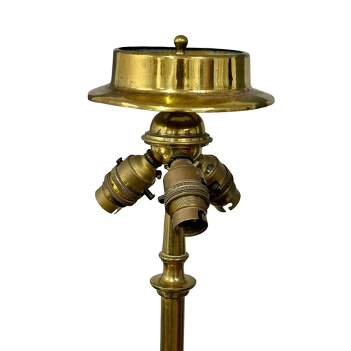 70 - A large good quality Early 20th Century brass standard lamp., with rams head decoration on hairy hoo... 