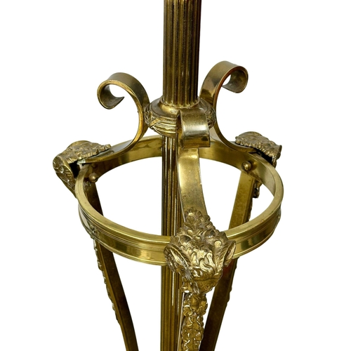 70 - A large good quality Early 20th Century brass standard lamp., with rams head decoration on hairy hoo... 