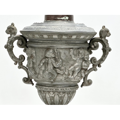 198 - A Late 19th Century pewter urn with cover. Converted into a lamp. With dancing cherub putti relief. ... 