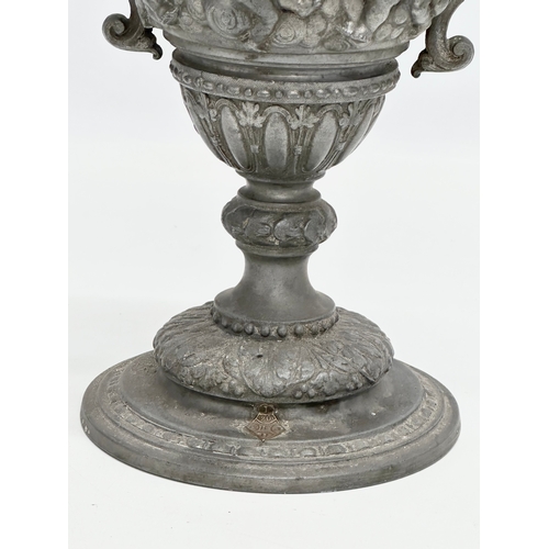 198 - A Late 19th Century pewter urn with cover. Converted into a lamp. With dancing cherub putti relief. ... 