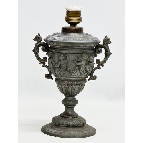 198 - A Late 19th Century pewter urn with cover. Converted into a lamp. With dancing cherub putti relief. ... 