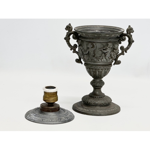 198 - A Late 19th Century pewter urn with cover. Converted into a lamp. With dancing cherub putti relief. ... 