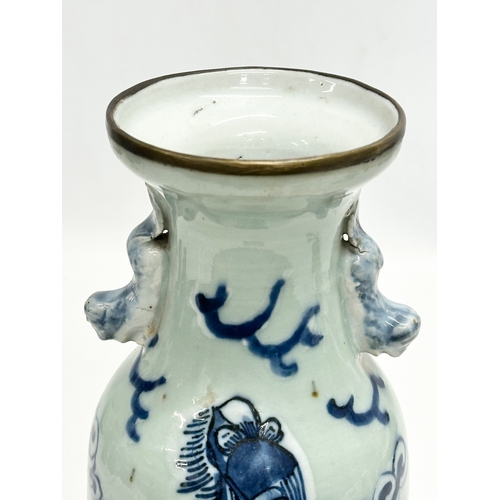 102 - A 19th Century Chinese celadon glazed baluster vase, with blue foo dog and brass rim. 24.5cm.