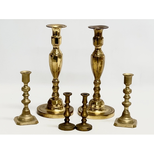 994 - Three pairs of brass candlesticks. 27cm. 15cm. 10cm.