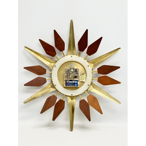 143 - Anstey & Wilson. A 1960’s Mid Century teak and brass sunburst clock. 43x48cm