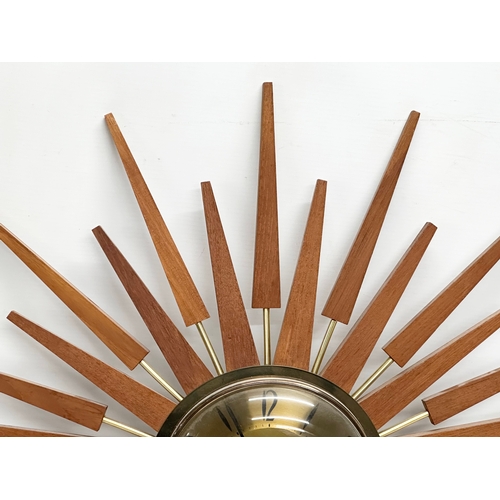 94 - Anstey & Wilson. A large 1960’s Mid Century teak sunburst clock. 63x63cm