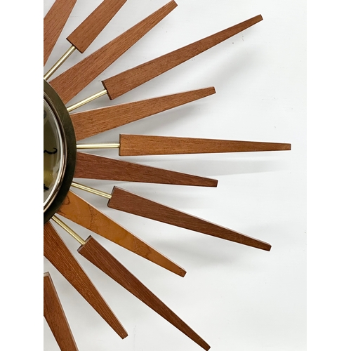 94 - Anstey & Wilson. A large 1960’s Mid Century teak sunburst clock. 63x63cm