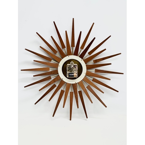 94 - Anstey & Wilson. A large 1960’s Mid Century teak sunburst clock. 63x63cm