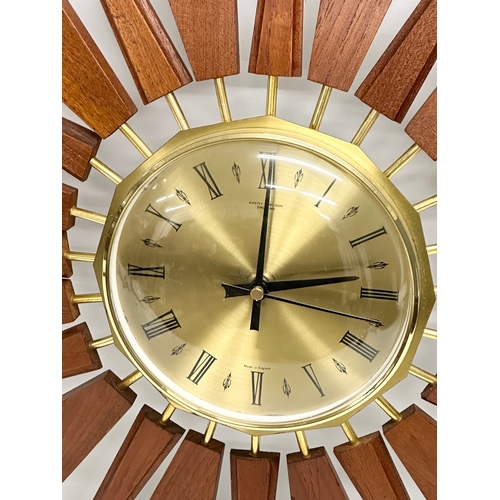 200 - Anstey & Wilson. A 1960’s Mid Century teak sunburst clock. 55x55cm