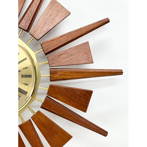 200 - Anstey & Wilson. A 1960’s Mid Century teak sunburst clock. 55x55cm