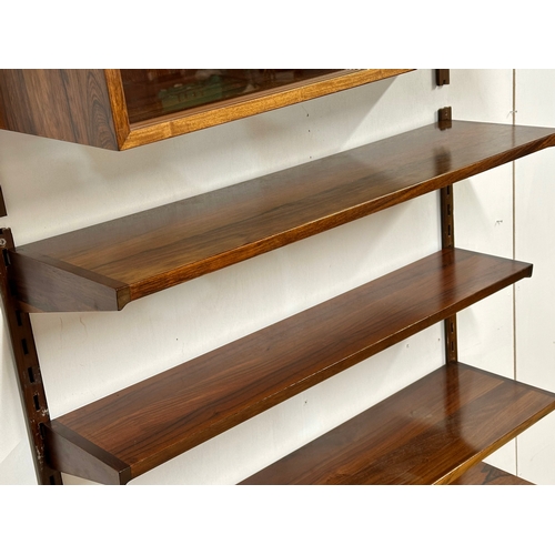 12A - Kai Kristensen. A Danish Mid Century rosewood wall modular shelving system. Designed by Kai Kristens... 