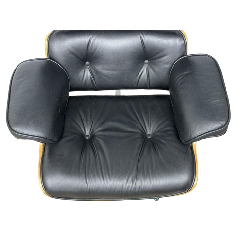 10 - A Charles & Ray Eames style leather swivel armchair and ottoman.