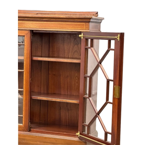 21 - A large good quality Early 20th Century Sheraton Revival inlaid mahogany bookcase, with astragal gla... 