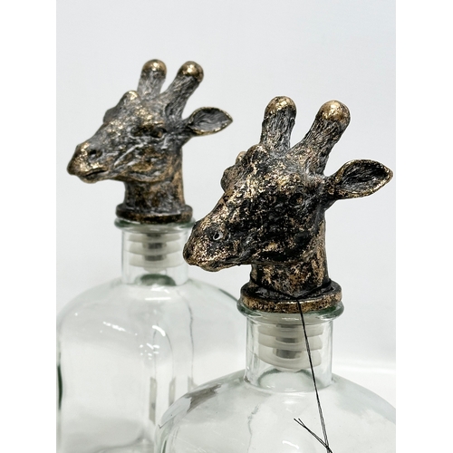 502 - A set of 4 novelty Giraffe and Rhino head glass decanters. 25cm