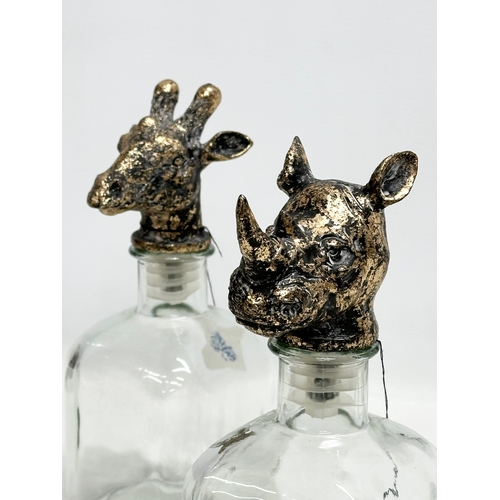 502 - A set of 4 novelty Giraffe and Rhino head glass decanters. 25cm