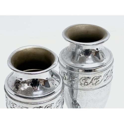 516 - A pair of Early 20th Century silver plated vases. 21cm