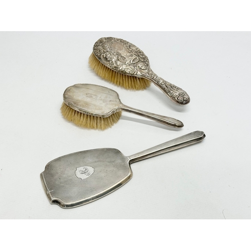 629 - 2 silver backed brushes and a vanity mirror.