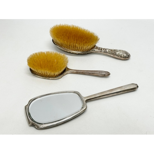 629 - 2 silver backed brushes and a vanity mirror.