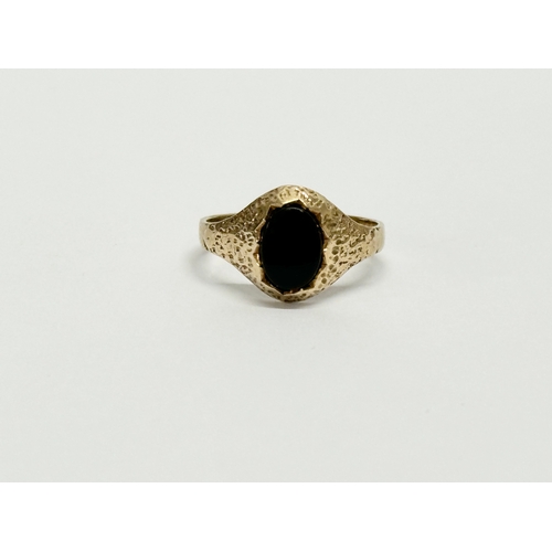 634 - A 9ct gold ring with black stone. 1.6 grams. Size K.    (10)