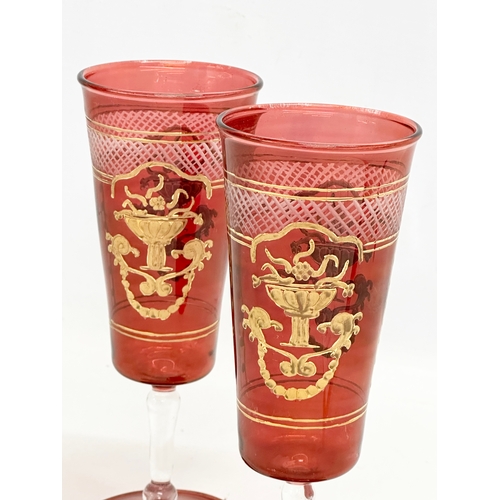 713 - Royal Sheffield Collection. A pair of gilt ruby “Royal Family” wine glasses. 20cm