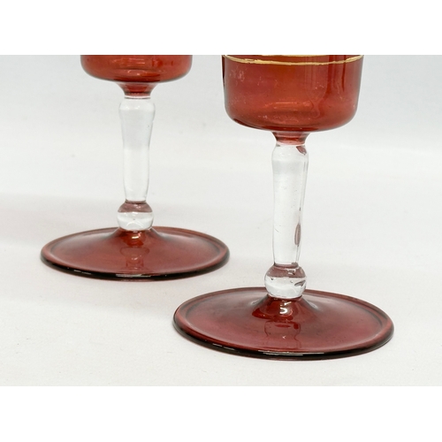 713 - Royal Sheffield Collection. A pair of gilt ruby “Royal Family” wine glasses. 20cm