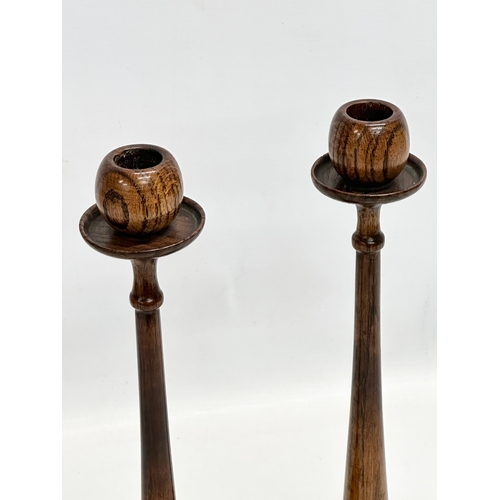 111 - A pair of tall Early 20th Century oak candlesticks. Circa 1910-1920. 33cm