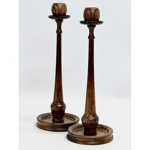 111 - A pair of tall Early 20th Century oak candlesticks. Circa 1910-1920. 33cm