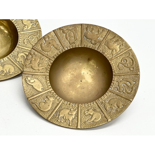 561 - A pair of Mid 20th Century Zodiac brass 12 sessions ashtray/bowls. 19x4cm