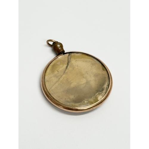 674 - An Early 20th Century 9ct gold pendant with photo.     (11)