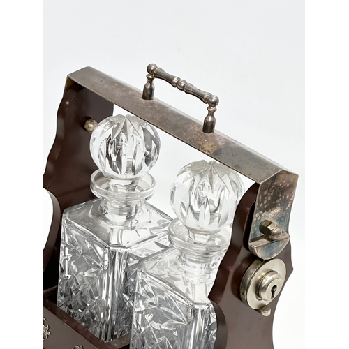 130 - A vintage tantalus and decanters. 26x30cm