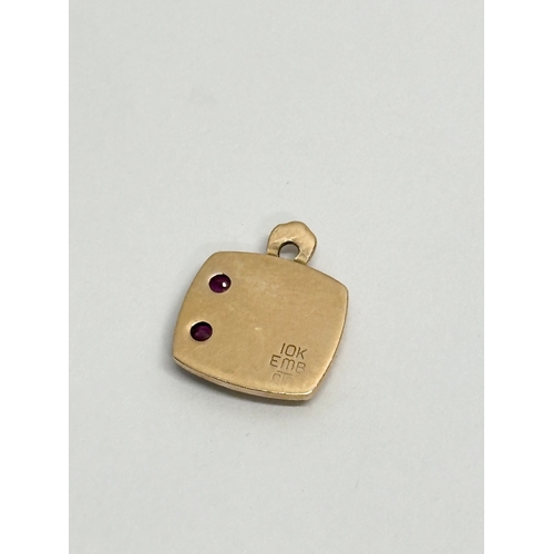 679 - A 10k gold pendant with garnets and shell logo. 2.95 grams.