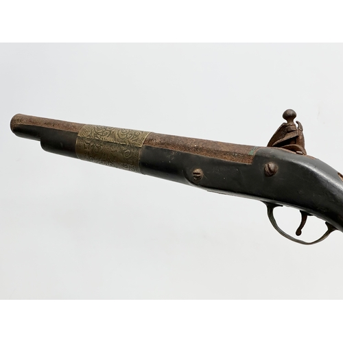 278 - A 19th Century Turkish percussion cap pistol and a British gunpowder flask. 44cm