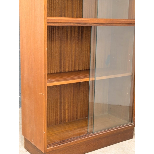 921 - A Mid Century teak bookcase with 4 sliding glass doors. 69x28x144cm (4)