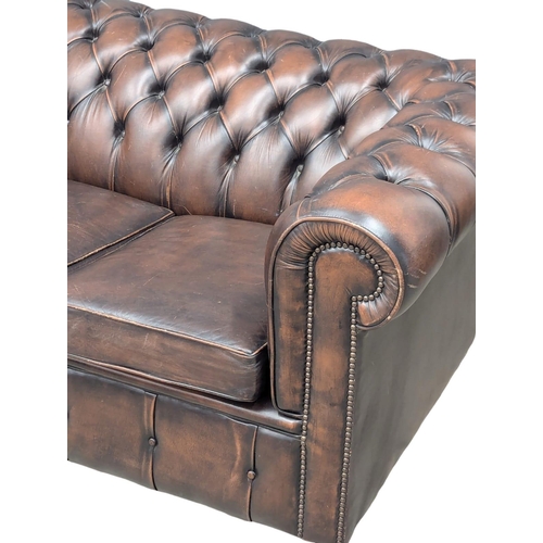 180 - A leather deep button back sofa. 184cm