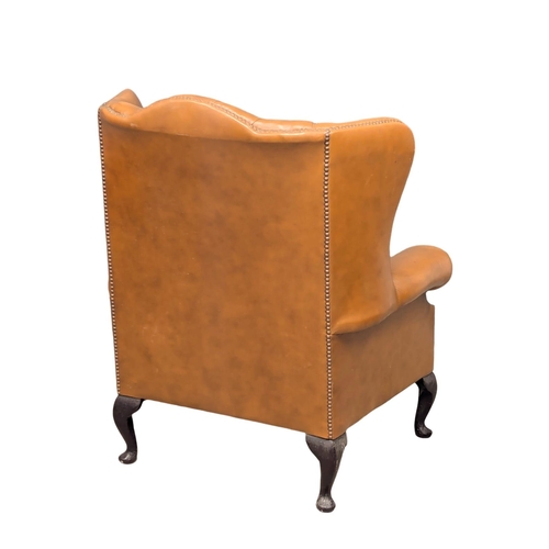 193 - A Georgian style deep button leather wingback armchair.