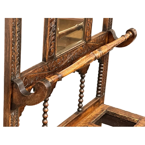 218 - A large Late 19th Century Victorian carved oak hallstand. With bobbin turn supports, front rail and ... 