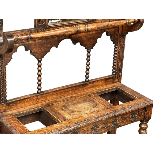 218 - A large Late 19th Century Victorian carved oak hallstand. With bobbin turn supports, front rail and ... 