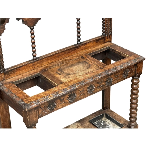 218 - A large Late 19th Century Victorian carved oak hallstand. With bobbin turn supports, front rail and ... 