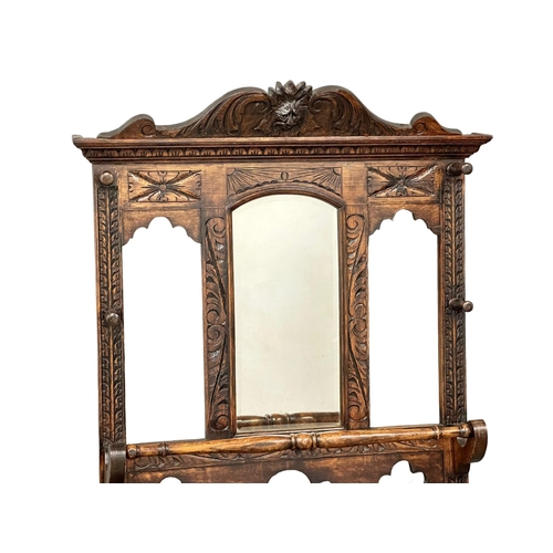 218 - A large Late 19th Century Victorian carved oak hallstand. With bobbin turn supports, front rail and ... 