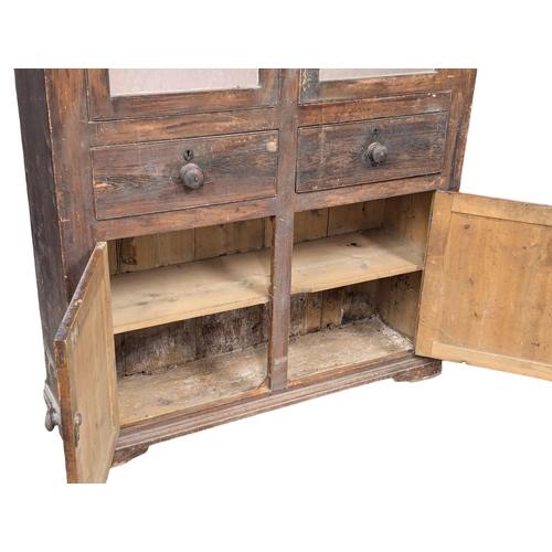 25 - A Mid 19th Century Irish pine kitchen cabinet in original scumble finish with fitted shaped shelves.... 