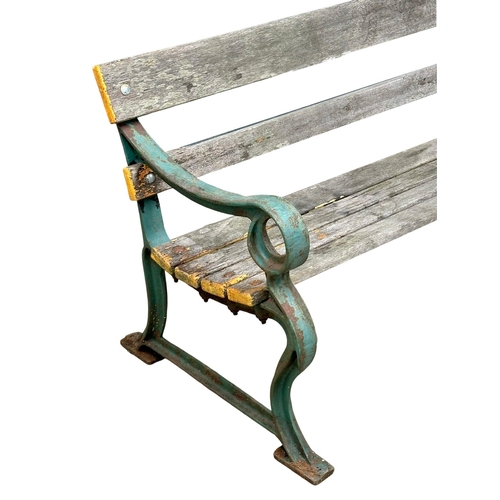 26 - A very large 19th Century Victorian cast iron garden bench with wooden straps. 240cm.