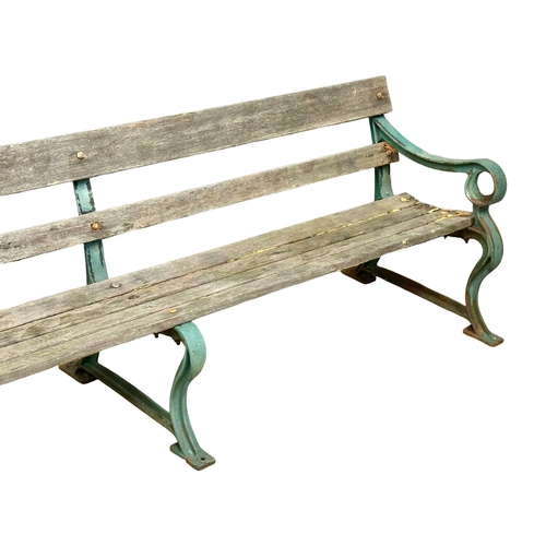 26 - A very large 19th Century Victorian cast iron garden bench with wooden straps. 240cm.