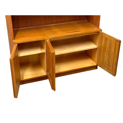 263 - A large Mid Century teak Chiswell open bookcase, with lower cupboard and maple interior. 118x45x222c... 