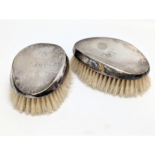 898 - A pair of Early 20th Century silver plated vanity brushes in case.   (6)