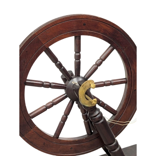 566 - A Victorian style mahogany spinning wheel.