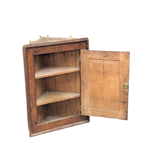 908 - A George III oak hanging corner cabinet. Circa 1800-1820. 68x35x89cm