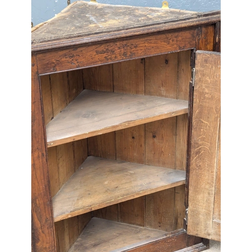 908 - A George III oak hanging corner cabinet. Circa 1800-1820. 68x35x89cm