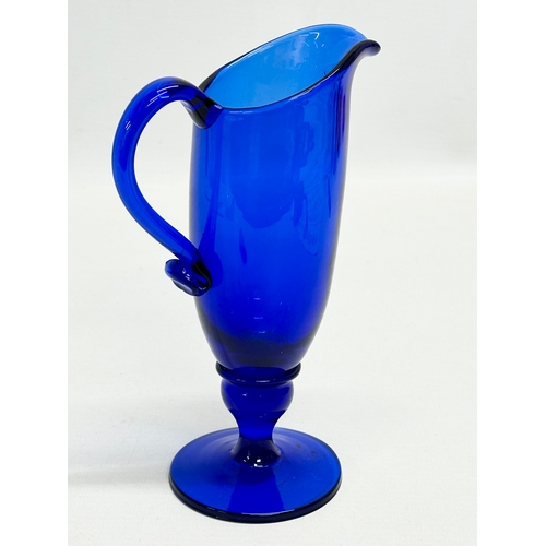 527 - An Early 20th Century Bristol Blue glass jug. 11x17.5cm.